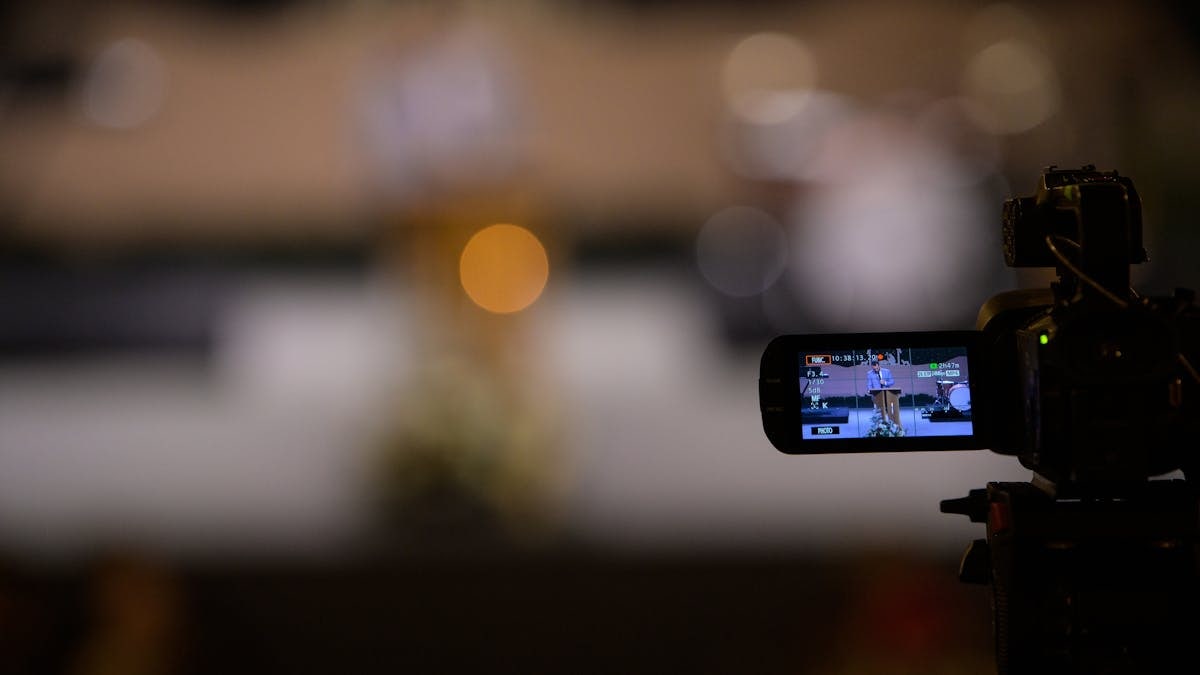 Video camera capturing an event with blurred bokeh background night scene.